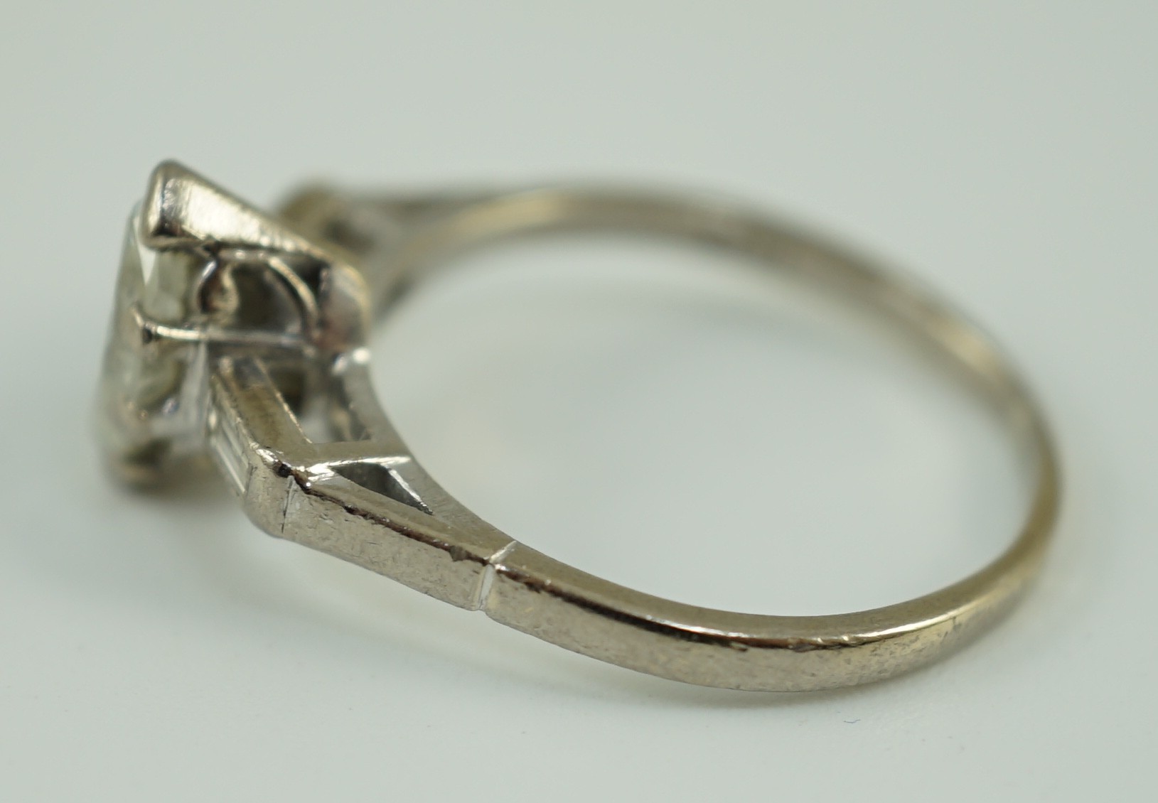 An 18ct white gold and single stone marquise cut diamond set ring, with baguette cut diamond set shoulders